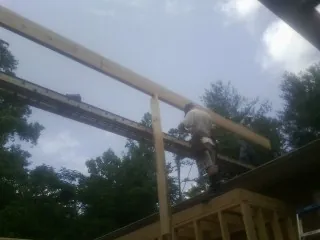 Carpenter setting a ridge beam over a new addition frame — Ice Dam Removal by Roofing Brothers in Downingtown
