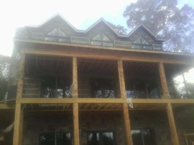 Dormers and porch framing on a large log home under construction — Roof Coating work by our crew in Downingtown