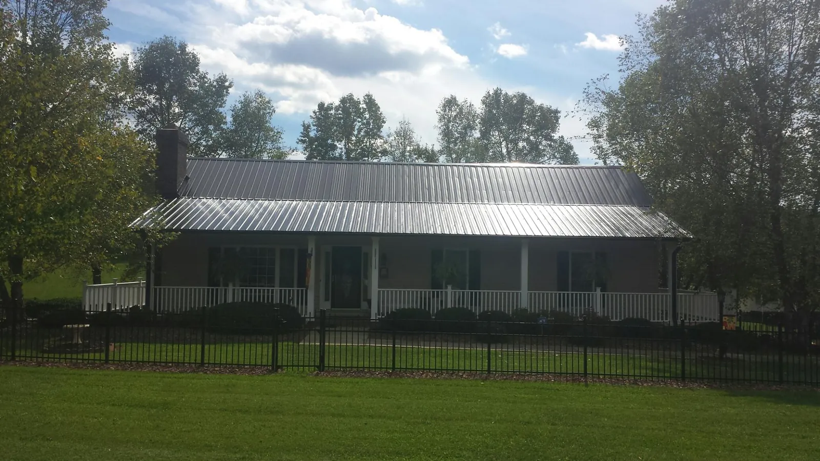 Gray metal roof on a brick ranch with a full width front porch — Gutter Guard Installation work by our crew in Downingtown